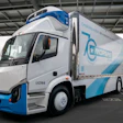 White and blue electric delivery truck with Morgan Motors branding parked under a covered structure