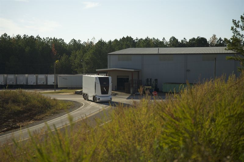 Einride's battery-electric, Level 4 autonomous cab-less truck parked alongside a warehouse during pilot operations.