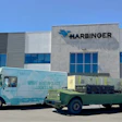 Harbinger corporate facility with branded delivery vehicles parked outside modern building