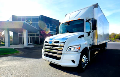 The new battery-electric Hino Trucks LE Series truck sits parked outside a building.