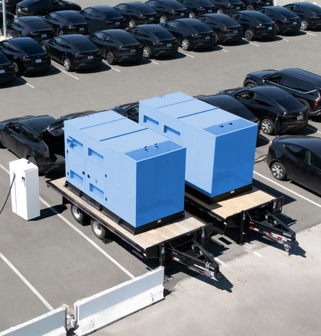 A pair of SparkCharge mobile, off-grid charging units on trailers parked at an electric vehicle fleet lot.