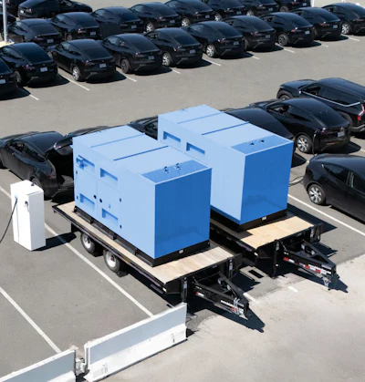 A pair of SparkCharge mobile, off-grid charging units on trailers parked at an electric vehicle fleet lot.