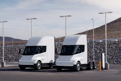 Two white Tesla Semis parked at a charging station.