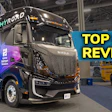 Nikola hydrogen fuel cell truck with blue and purple branding displayed at trade show next to yellow school bus