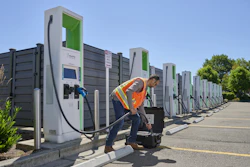 A worker connects the new Fluke FEV500 to a fast charger at a fleet charging depot.