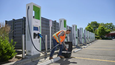 A worker connects the new Fluke FEV500 to a fast charger at a fleet charging depot.