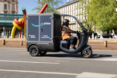 An Amazon Prime electric delivery tricycle driving in a European city.
