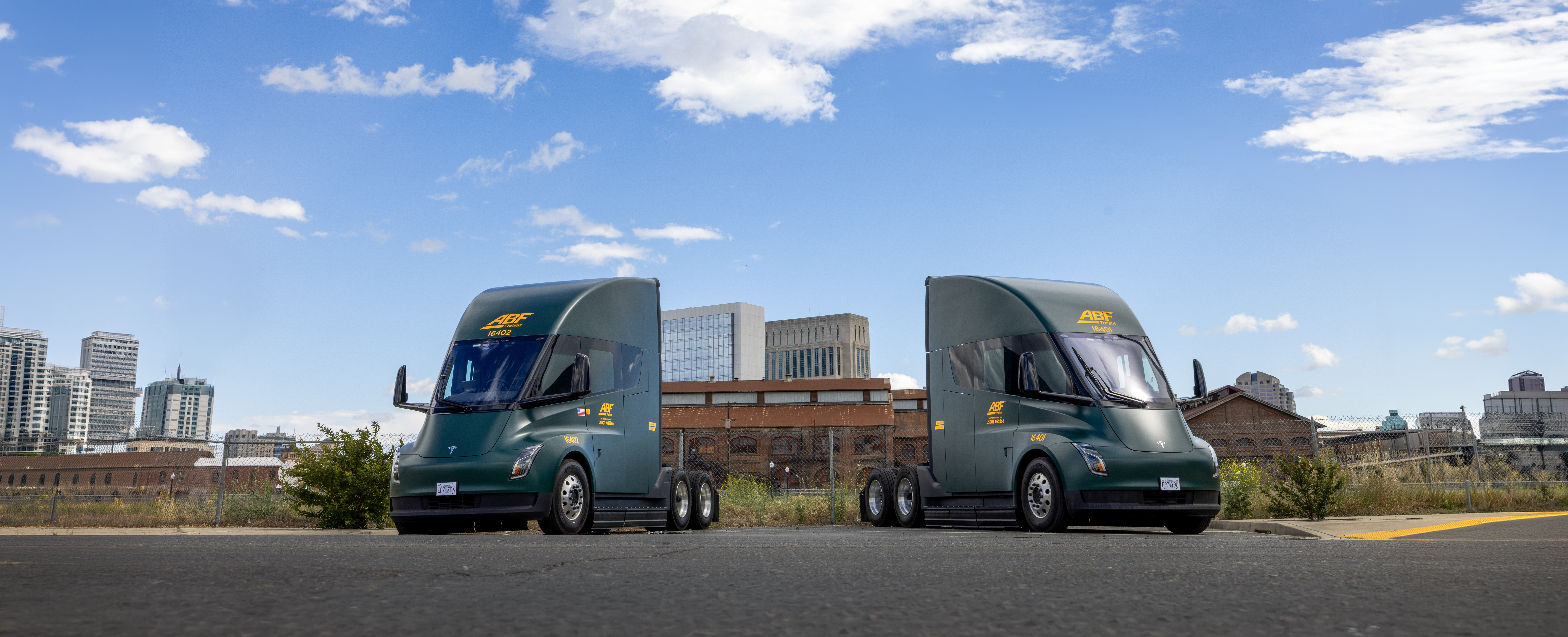 Two ArcBest-branded Tesla Semi trucks parked outside an ABF Freight facility.