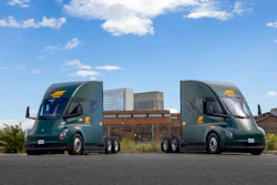 Two ArcBest-branded Tesla Semi trucks parked outside an ABF Freight facility.