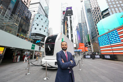 Einride CEO Roozbeh Charli stands outside Nasdaq in Times Square on June 10, 2026, with an autonomous battery-electric truck parked behind him.