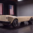 Vintage cream-colored Harbinger unmanned hybrid-electric-military platform displayed in showroom with American flags
