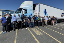 Employees from Optimus Technologies, Perdue Farms, and the Maryland Soybean Board stand in front of a biodiesel-powered Volvo semi-truck.