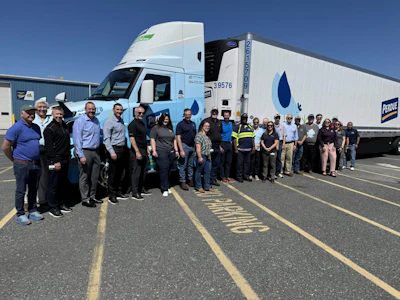 Employees from Optimus Technologies, Perdue Farms, and the Maryland Soybean Board stand in front of a biodiesel-powered Volvo semi-truck.