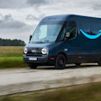 Amazon Prime delivery van driving on a rural road with green fields in background