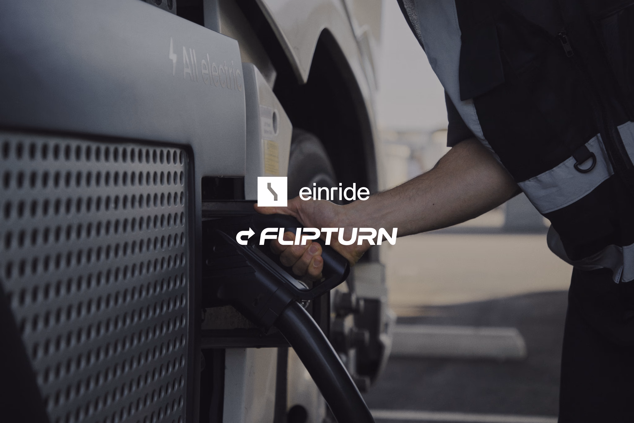 An individual is shown charging an electric semi-truck with the Einride and Flipturn brand logos on display.