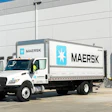 White Maersk delivery truck parked at warehouse loading dock with numbered bay doors