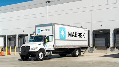 A white Maersk delivery truck sits outside a warehouse loading dock, highlighting the company’s expanding ground freight operations.