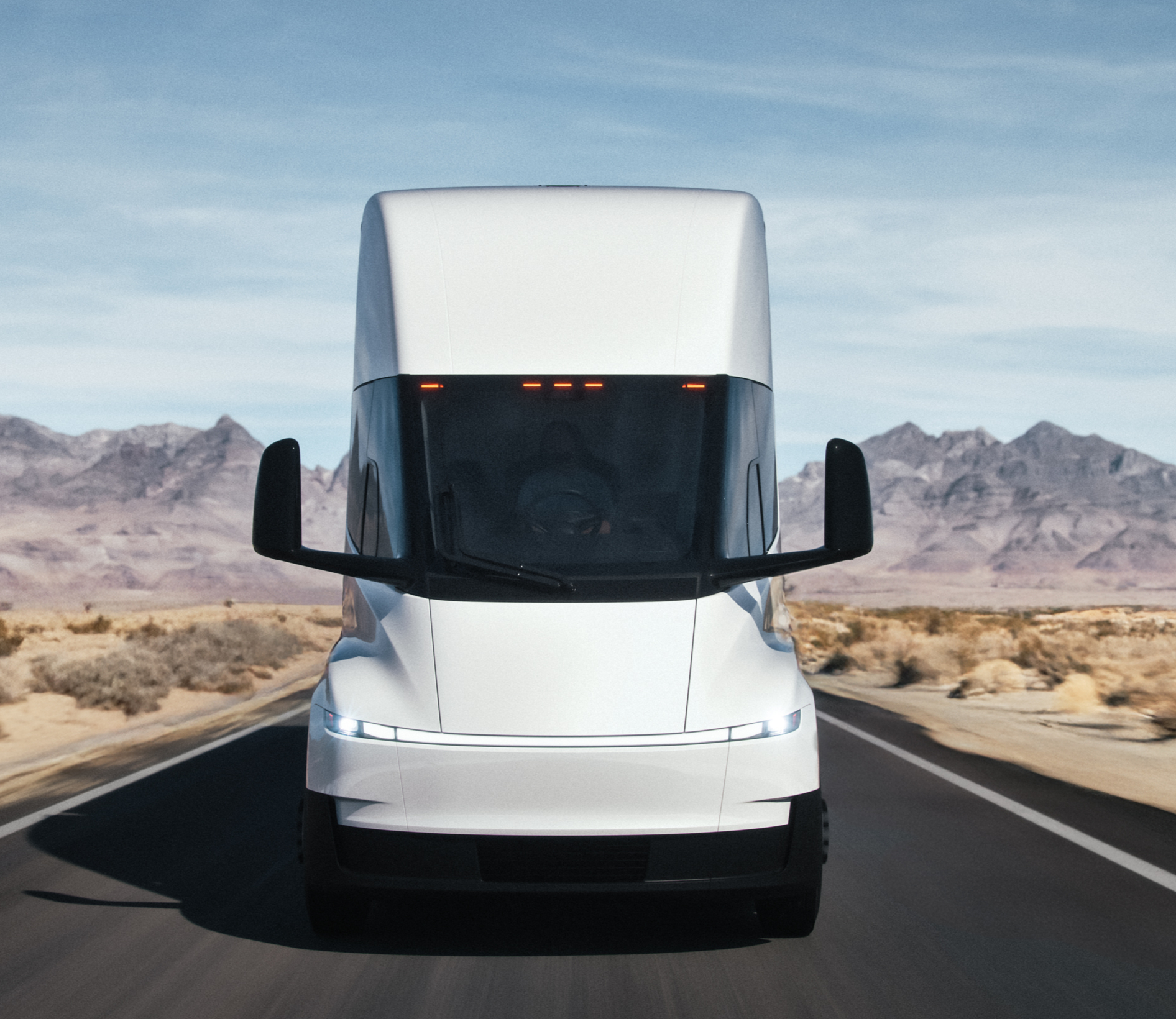 A front view of the updated Tesla Semi driving along a highway.