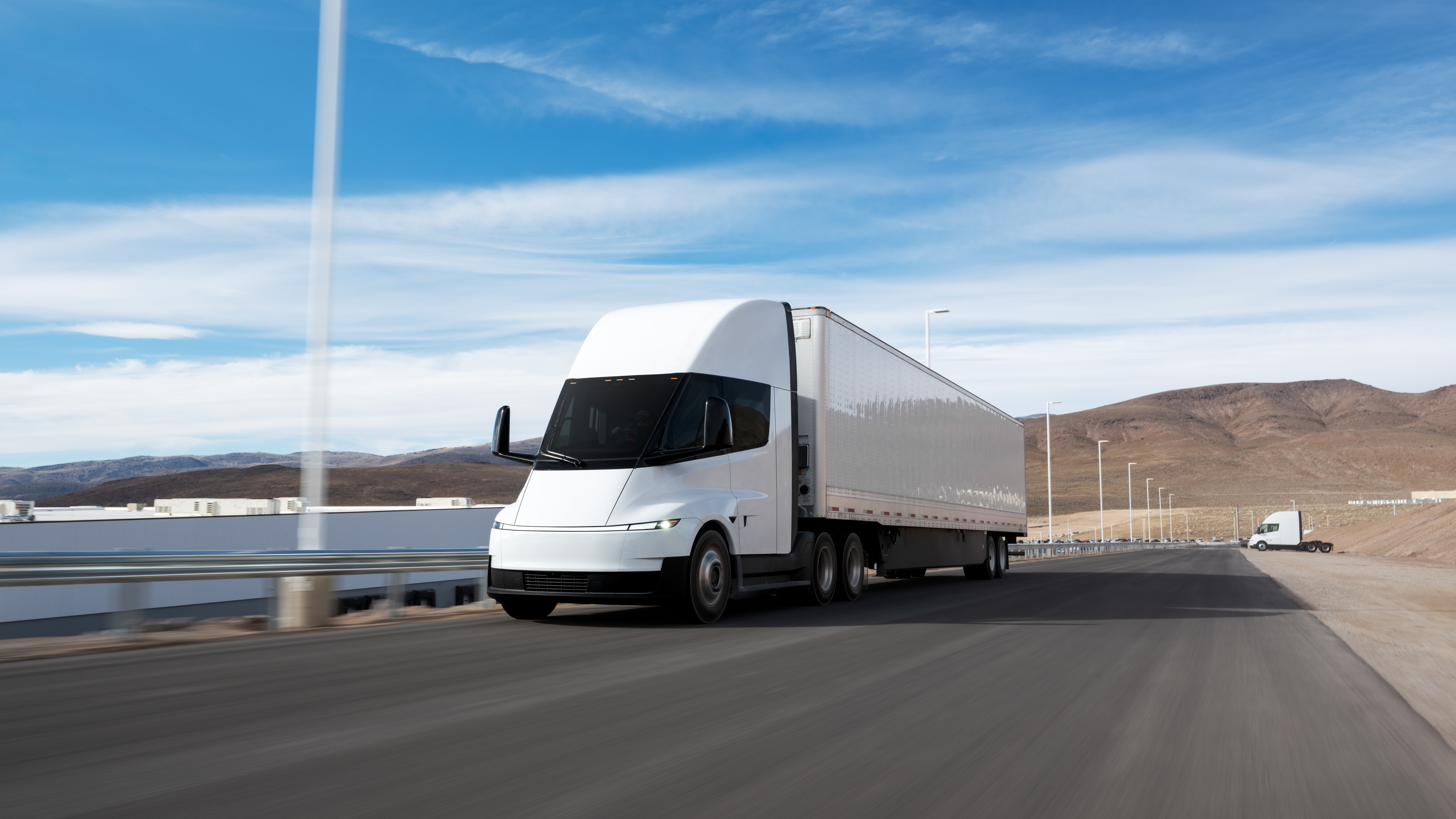 A rendering of the Tesla Semi hauling a trailer along a highway.