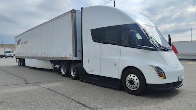 Paper Transport Inc.'s Tesla Semi Long Range is shown with a loaded trailer in an industrial yard during the company's Chicago pilot program.