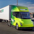 WattEV electric semi-truck with lime green cab and white cargo trailer at industrial facility