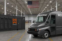 A Workhorse battery-electric step van parked beside a branded mobile AI data center unit inside a warehouse.