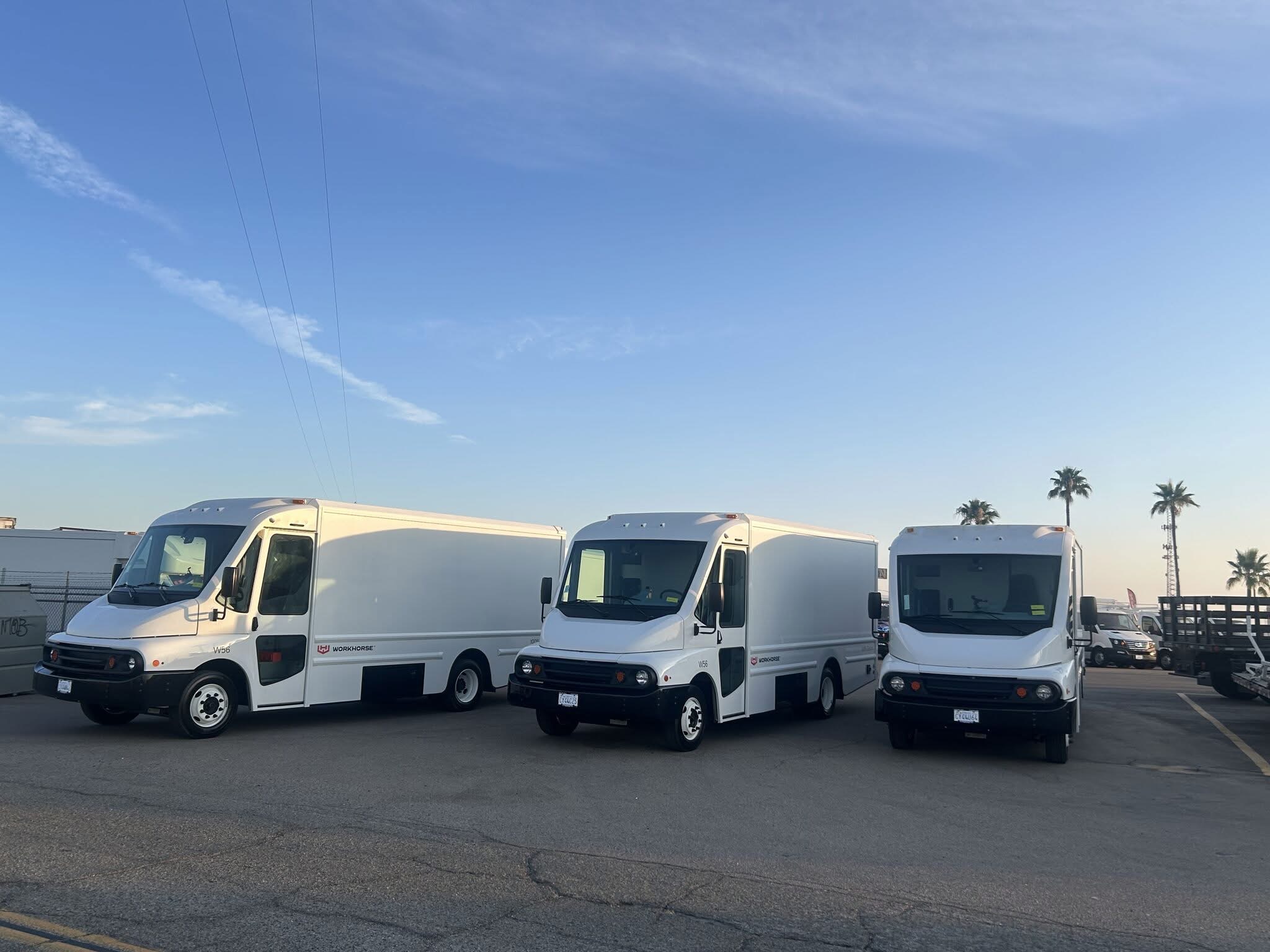Three battery-electric Workhorse W56 step vans in a parking lot.