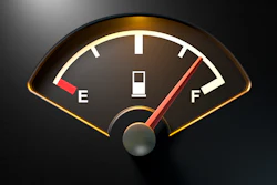 Analog fuel gauge with needle pointing to quarter tank, featuring E and F indicators on dark background