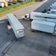 Aerial view of commercial truck yard with multiple white delivery trucks and trailers parked in organized rows on asphalt