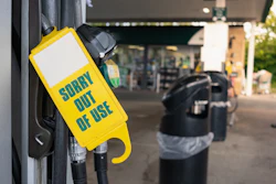 Yellow 'Sorry Out of Use' safety tag on gas pump nozzle at service station