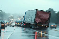 Multi-vehicle highway collision on wet freeway during rainy conditions with truck and passenger cars