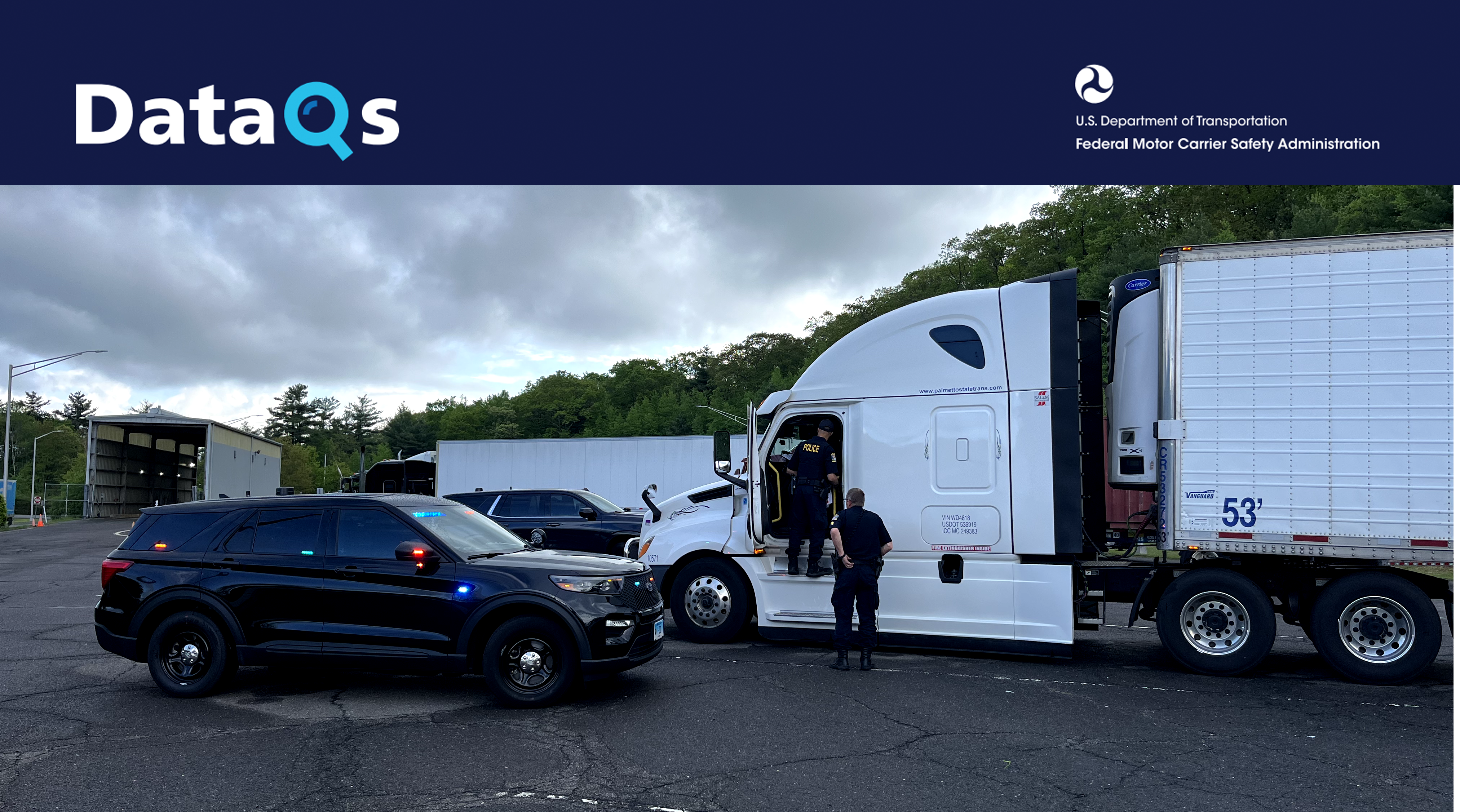Law enforcement officer and commercial truck driver at roadside safety inspection checkpoint