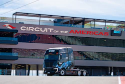 Circuit of the Americas racing venue with blue race truck parked beneath branded signage on multi-story facility