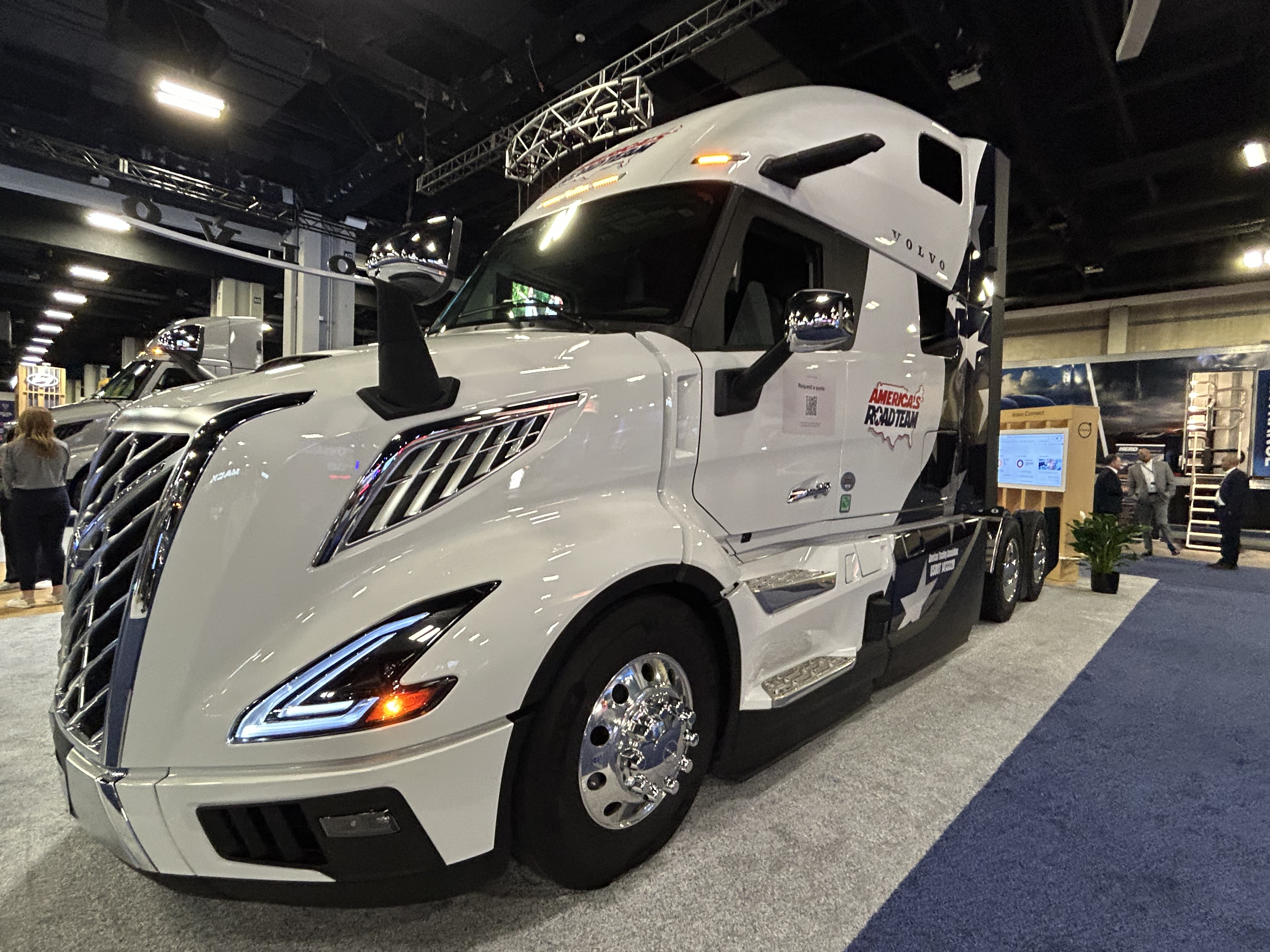 White Volvo semi-truck with sleek design displayed at indoor trade show exhibition
