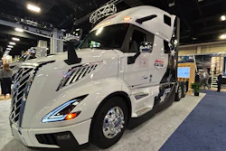 White Volvo semi-truck with sleek design displayed at indoor trade show exhibition