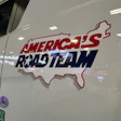 America's Roadteam logo decal on white RV exterior with red and blue text and map outline