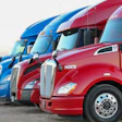 Fleet of blue and red semi-trucks lined up with Knight Transportation branding displayed on vehicles