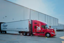 Red Kodiak semi-truck with white Charger Logistics trailer parked at industrial facility