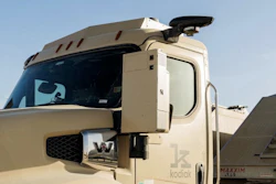 Cream-colored autonomous truck with Kodiak Robotics branding and black mirror assembly against clear sky