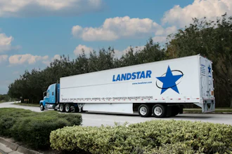 Landstar semi-truck with blue cab and white trailer featuring company logo traveling on highway with trees and blue sky