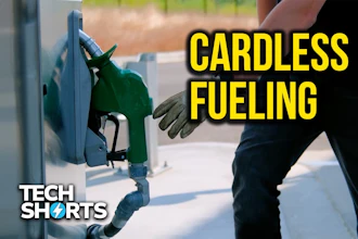 Person using cardless fueling technology at green gas pump nozzle