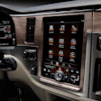 Vehicle dashboard with touchscreen infotainment system displaying apps and controls