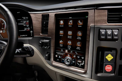 Vehicle dashboard with touchscreen infotainment system displaying apps and controls