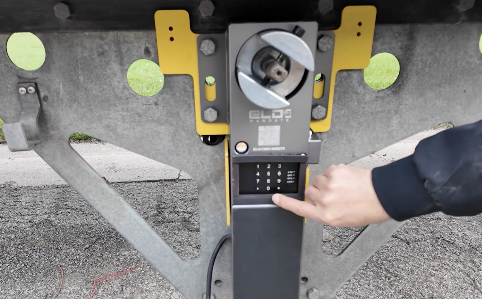 Person's hand using yellow and gray parking meter payment kiosk with digital screen